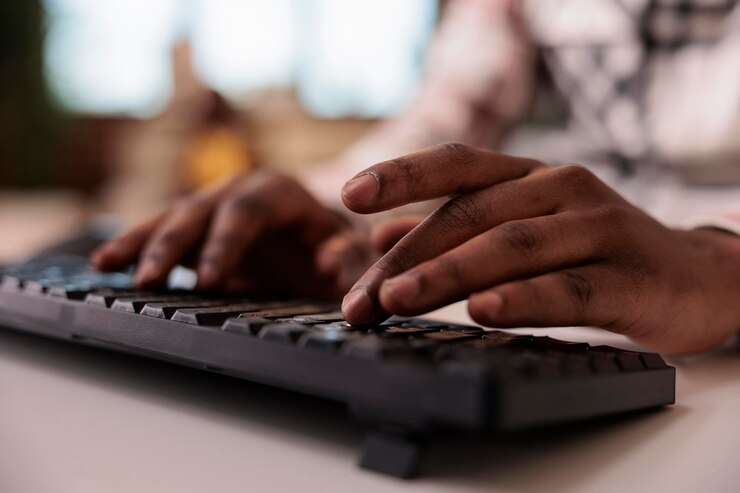 closeup-african-american-male-content-creator-writing-post-social-media-computer-keyboard-home-living-room-selective-focus-man-hands-working-remote-typing-blog-article